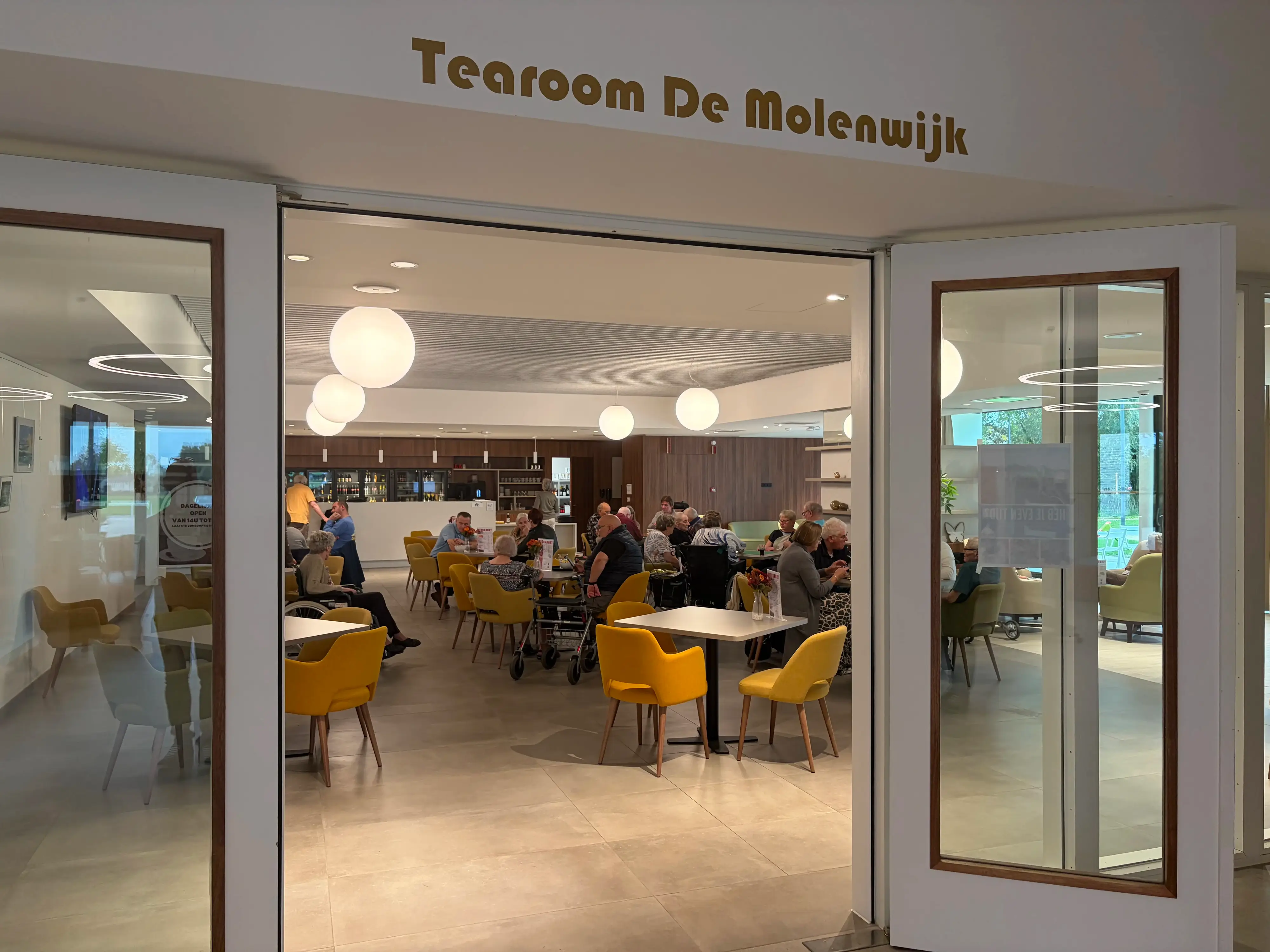 Tearoom van WZC Sint-Pietersmolenwijk met veel volk rond de tafels
